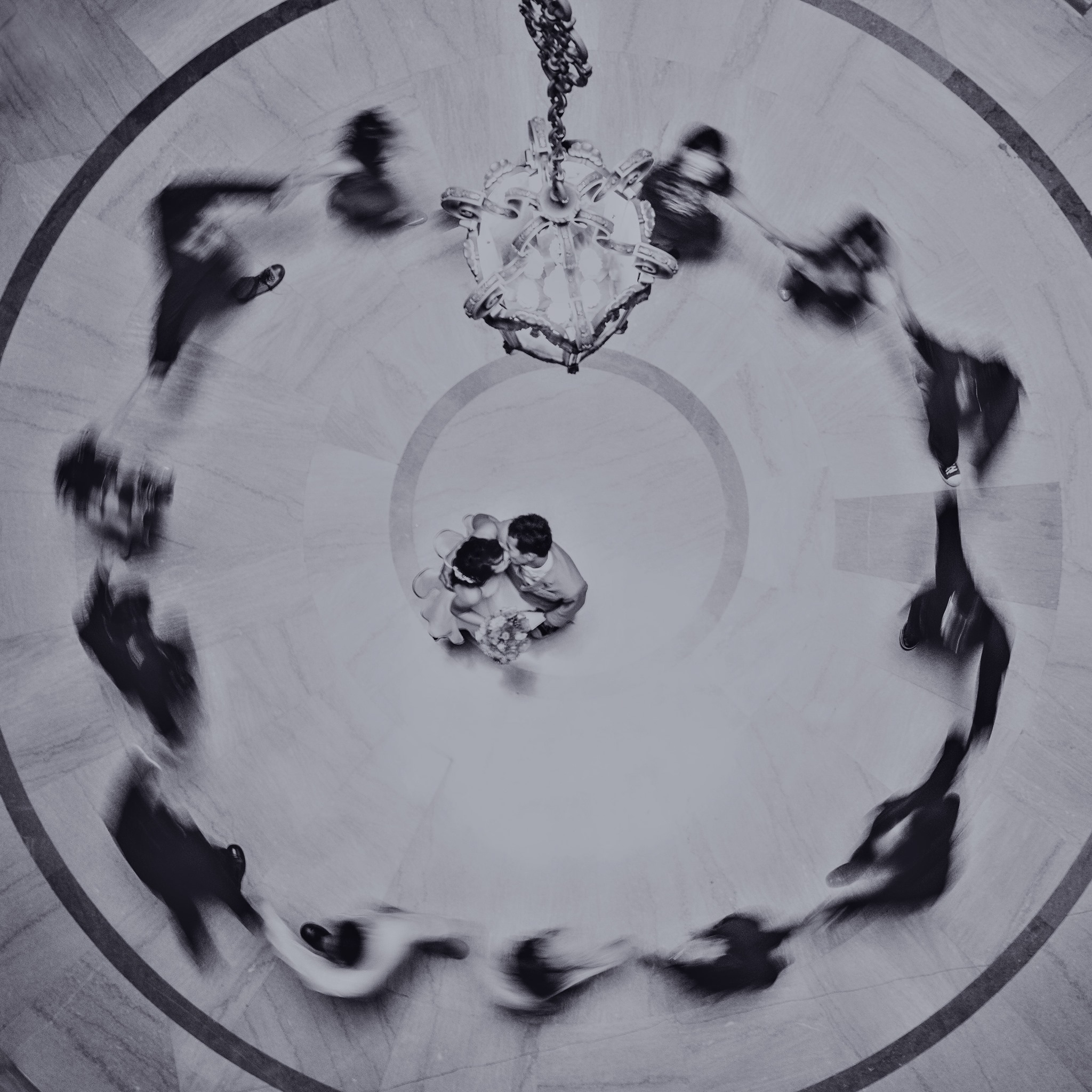 A bird eye's view of a couple dancing at the center of a circle created by the bridesmaid and groomsmen