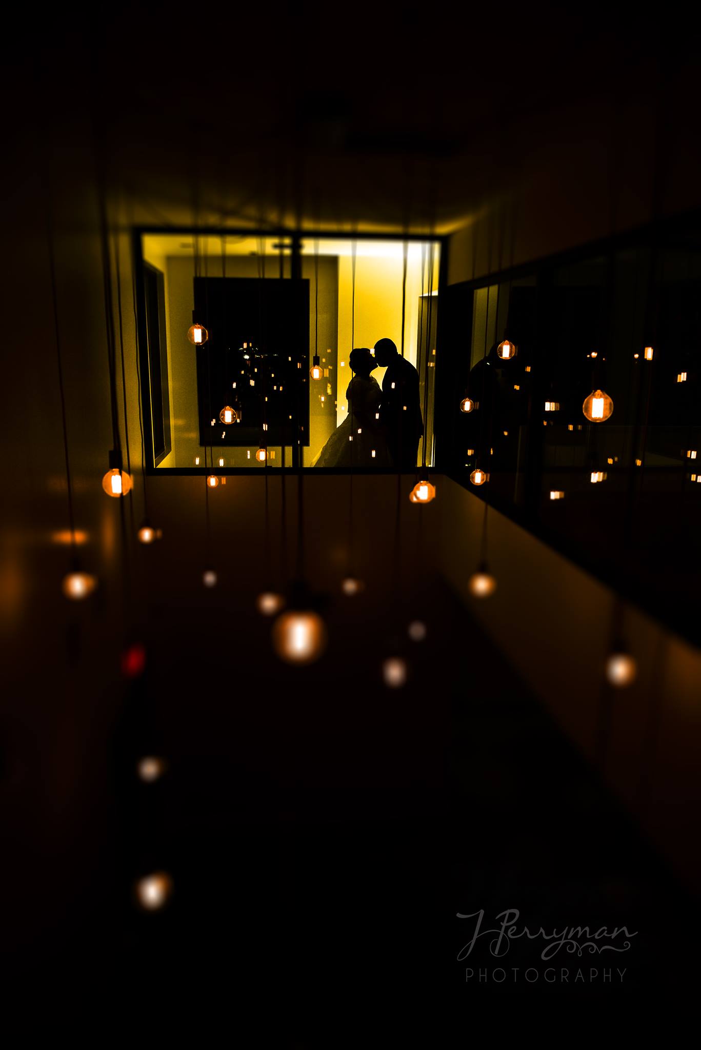 Silhouette of a couple kissing framed through a window 