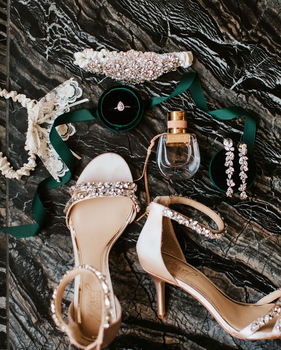 A close up shot of a wedding ring, bride's sandals, and other bridal accessories