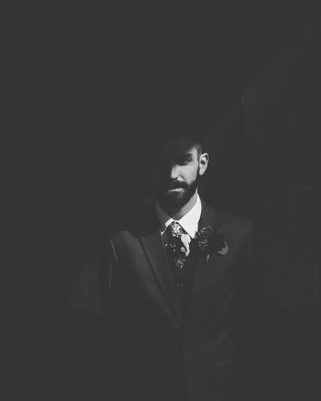 A groom's portrait with his face half in the light and half in shadow