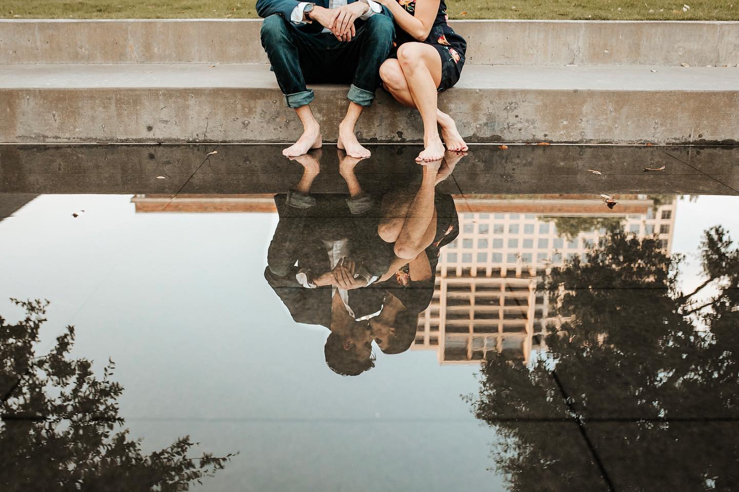 A reflection of a couple posing for a kiss while sitting on the stairs