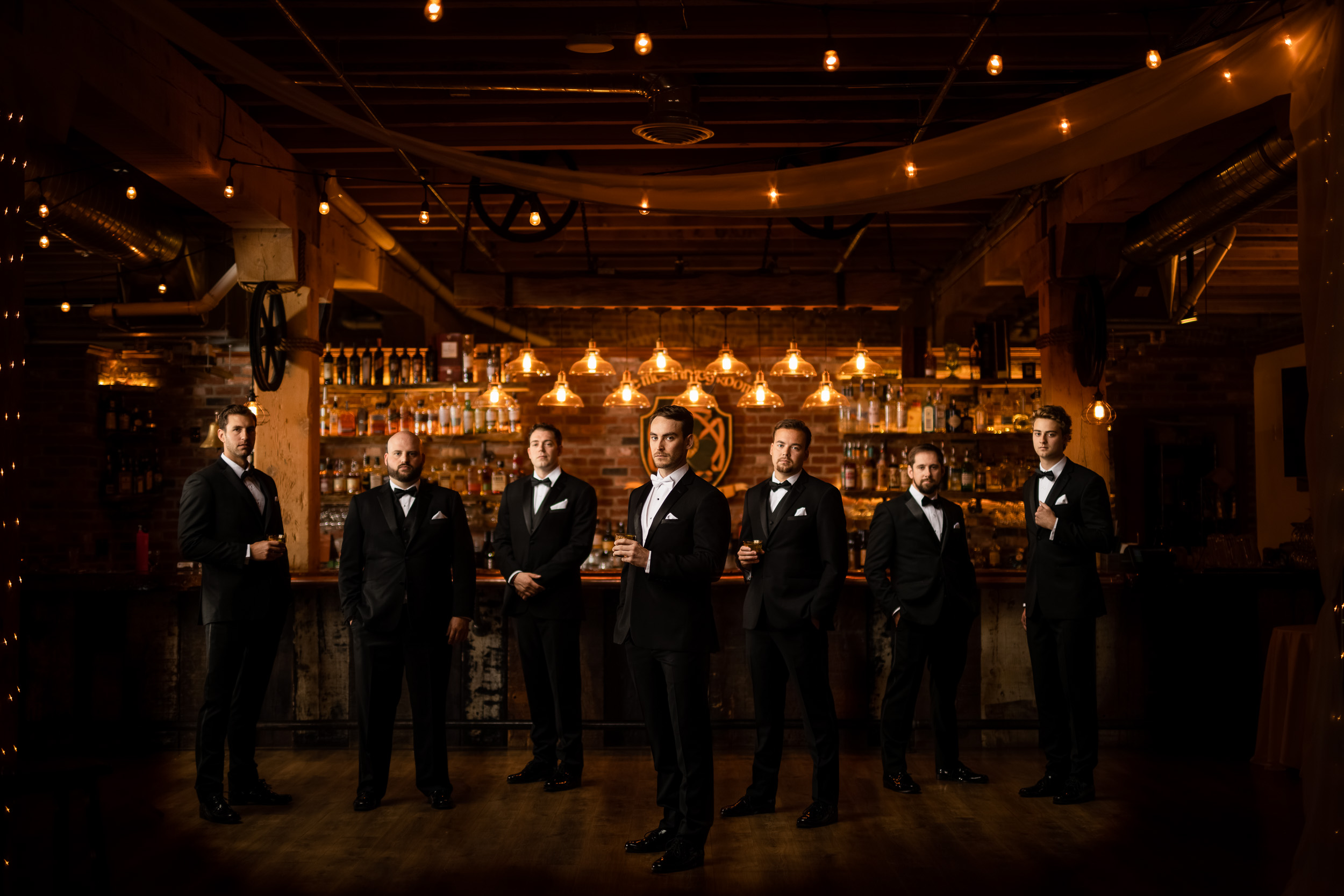 The groom and groomsmen posing in a bar