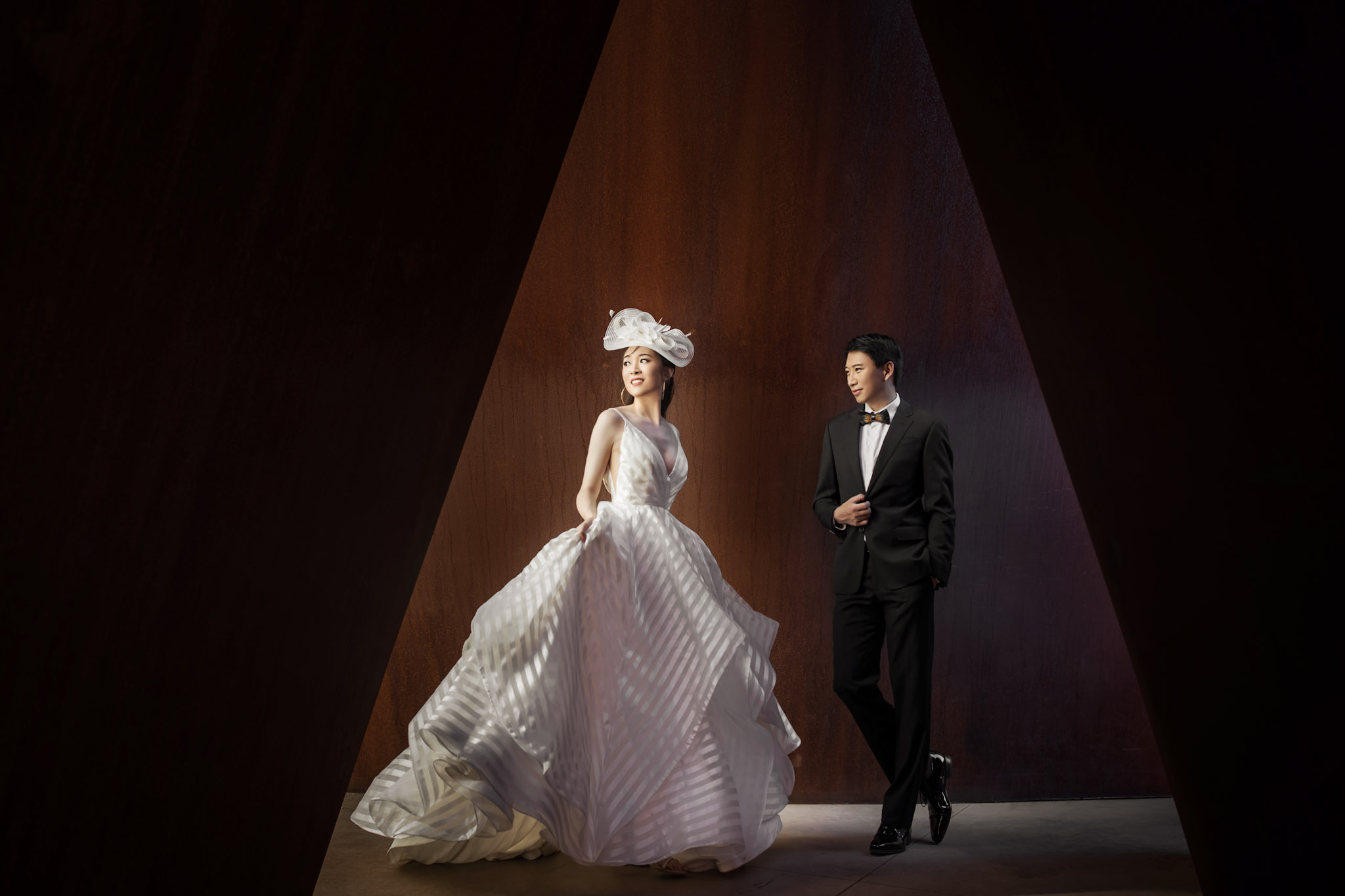 a bride and a groom in wedding attire posing